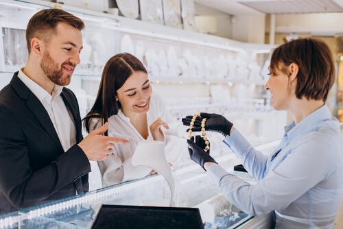 זוג בחנות תכשיטים בוחר תכשיט שיתאים ללבוש האישה