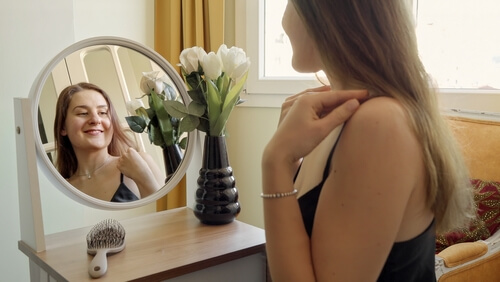 בחורה עונדת תכשיטים לקראת אירוע חברה